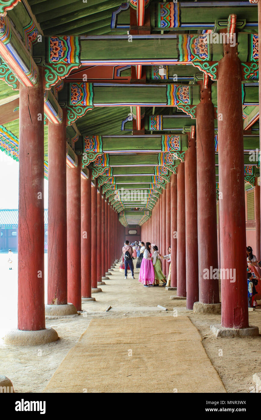 Passage couvert avec piliers rouge et vert hors plafond décoratif d'une cour au Palais Gyeongbokgung, Séoul, Corée Banque D'Images
