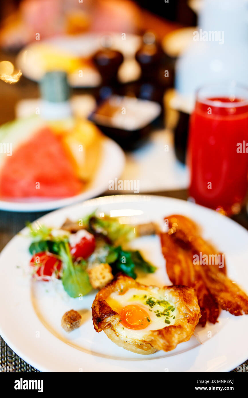 Tarte aux oeufs servis pour le petit-déjeuner avec des légumes, du café et des jus de fruits Banque D'Images