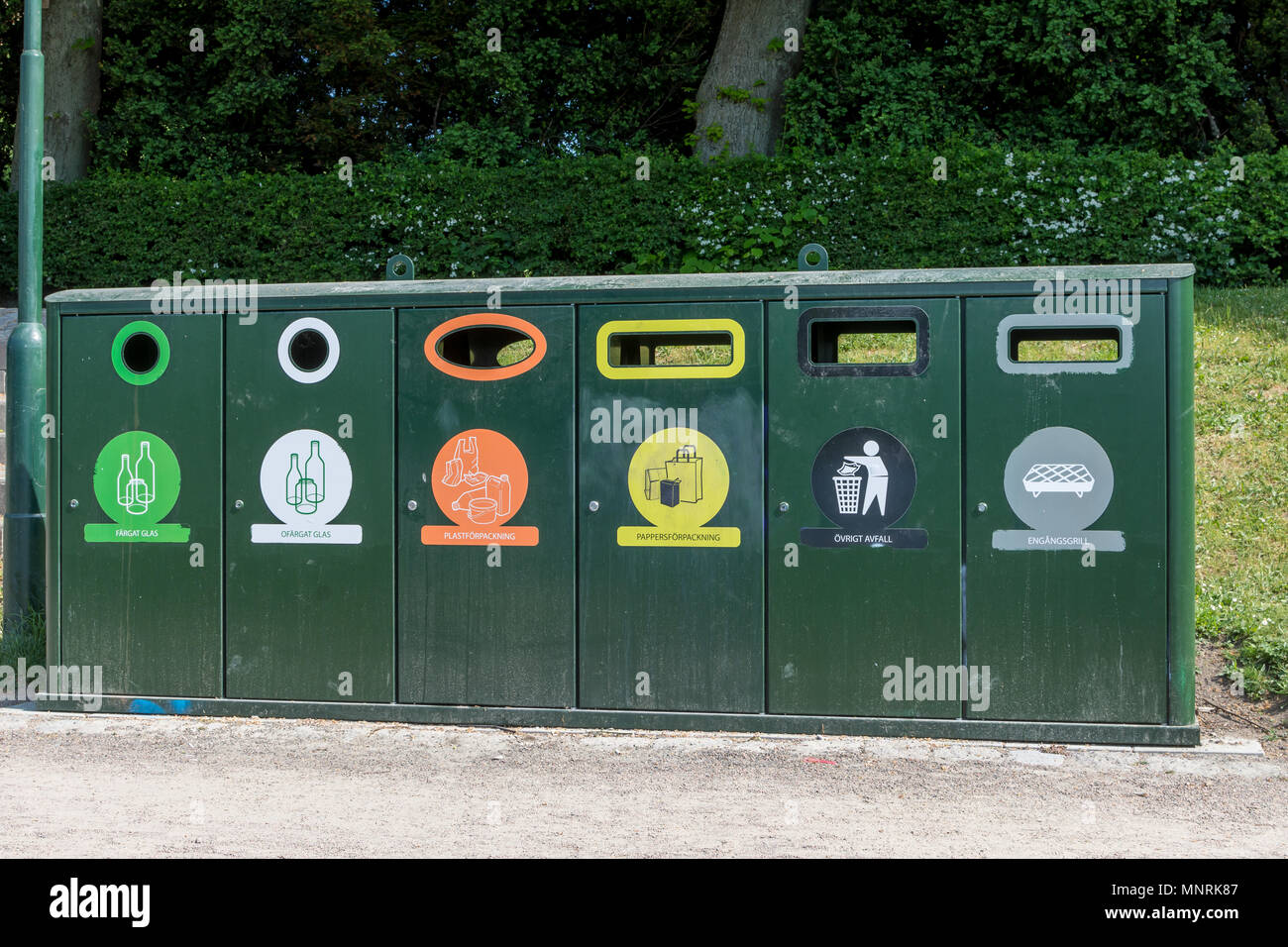 Bac de recyclage vert en parc avec des bacs de plastique, bouteilles en verre, les denrées alimentaires, des déchets en général, et des barbecues Banque D'Images
