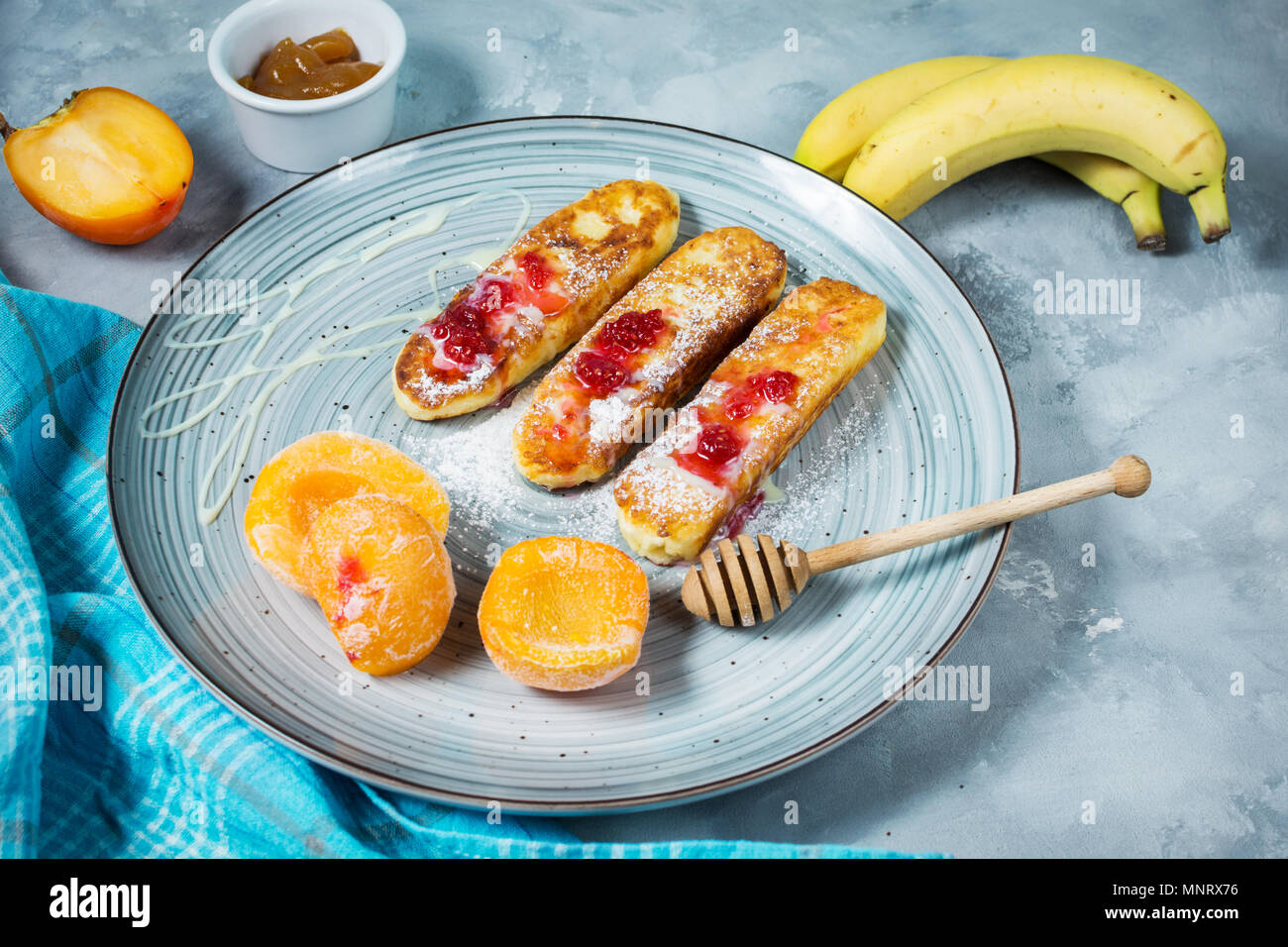 Crêpes de fromage cottage avec l'avoine, syrniki et pêche sur fond de béton. Banque D'Images