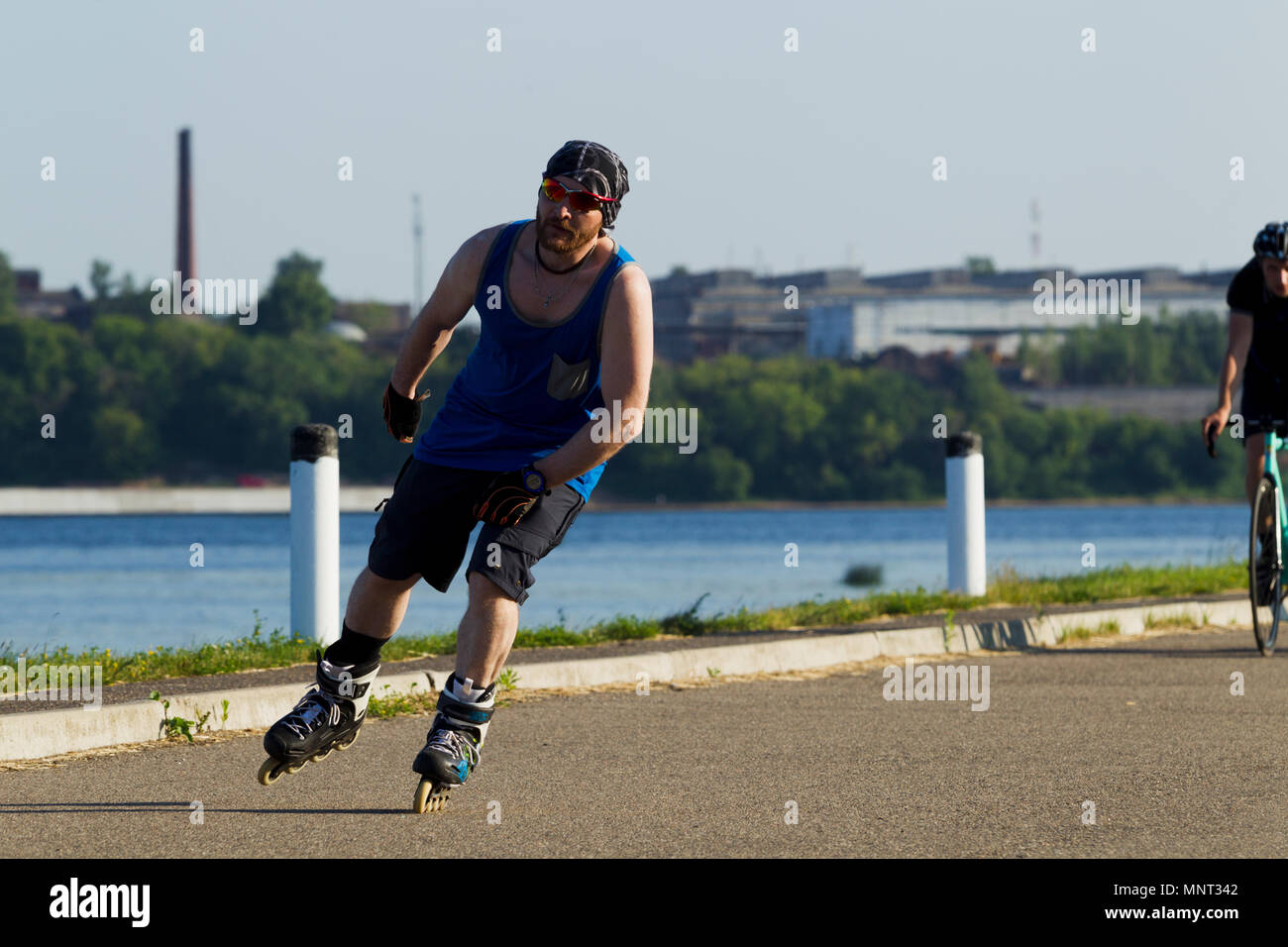 Homme monté sur patins à dans la ville de cyclistes de l'arrière-plan, éclairée par la lumière du soleil Banque D'Images