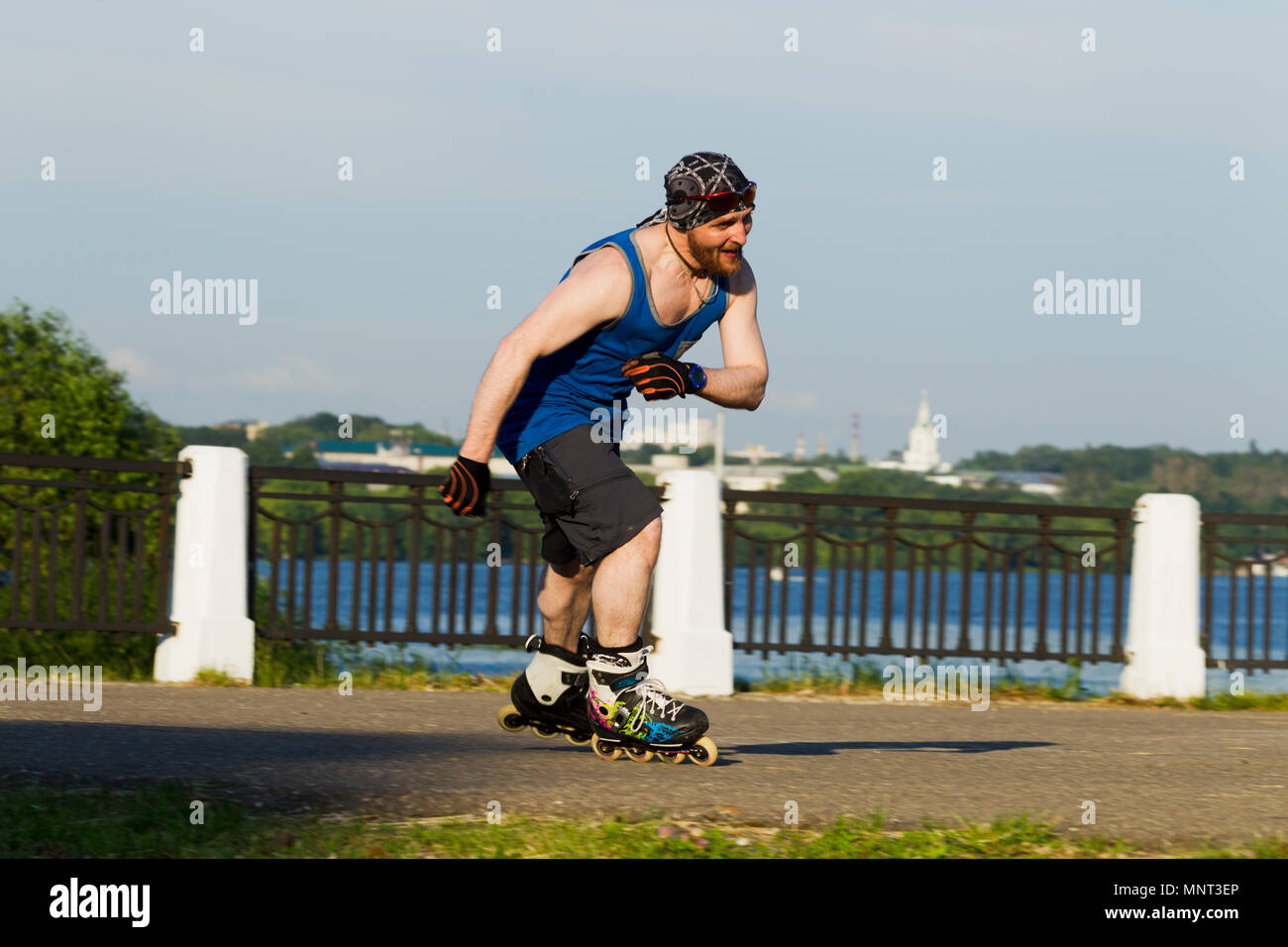 Homme monté sur patins à roulettes dans la ville, éclairées par la lumière naturelle Banque D'Images