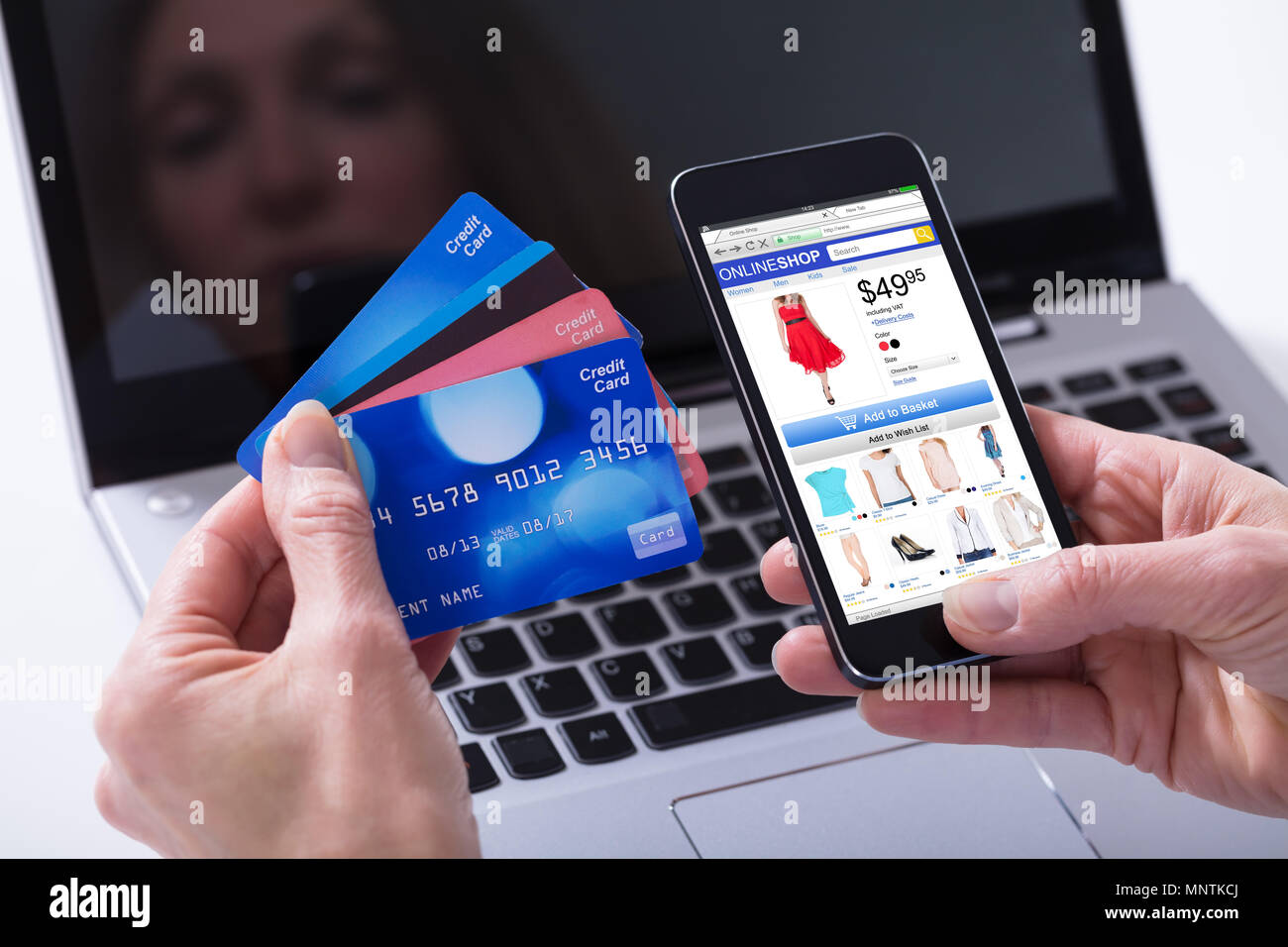 Close-up of a Woman Shopping online par carte de crédit sur téléphone mobile contre ordinateur portable Banque D'Images