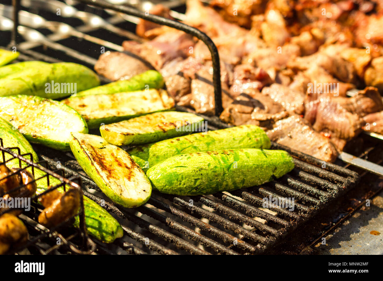 La viande sur grill ou shish kebab et processus de cuisson des légumes. Sur la frite en brochettes sur charbon chaud. Dégustation traditionnelle pour pique-nique. Close-up. Banque D'Images