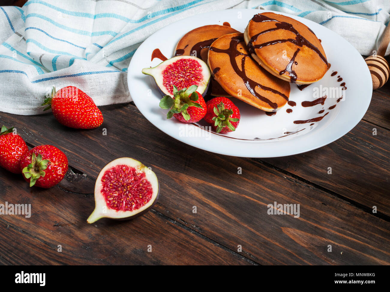 Pancakes aux figues, fraises sur plaque blanche libre. Banque D'Images