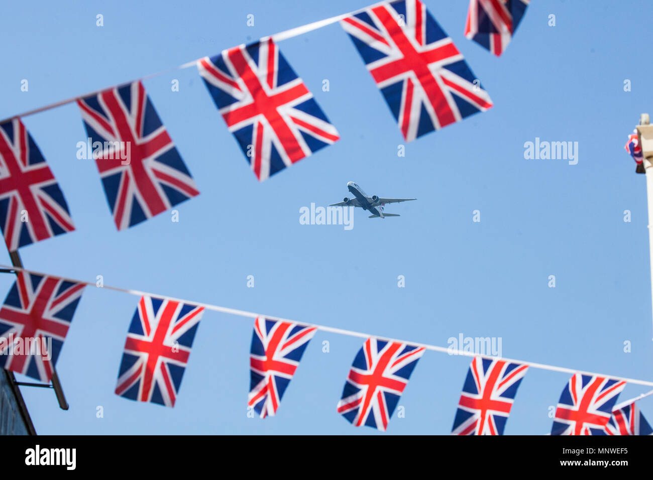 Windsor, Royaume-Uni. 19 mai, 2018. Un avion de l'aéroport d'Heathrow vole au-dessus de banderoles accrochées dans une rue du centre-ville le jour du mariage à la Chapelle St George du château de Windsor, le prince Harry et Meghan Markle, maintenant, le duc et la duchesse de Cambridge. Credit : Mark Kerrison/Alamy Live News Banque D'Images
