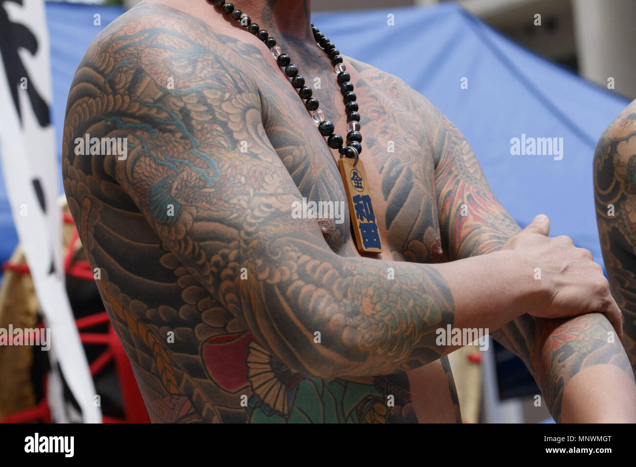 Tokyo, Japon. 20 mai, 2018. Un homme montrant son corps plein tatoués, peut-être un membre de la mafia japonaise ou Yakuza, Sanja Matsuri assiste au district à Asakusa. Le Sanja Matsuri est l'un des plus grands festivals Shinto à Tokyo, et c'est tenue à Tokyo Asakusa du district pour trois jours autour de la troisième semaine de mai. De grands groupes de personnes habillé des vêtements traditionnels pour porter Mikoshi (sanctuaires portables sacré) entre les rues à proximité de Temple Sensoji à apporter des bénédictions et fortune à les habitants de la communauté voisine à Asakusa pendant les deuxième et troisième jour du festival. Banque D'Images