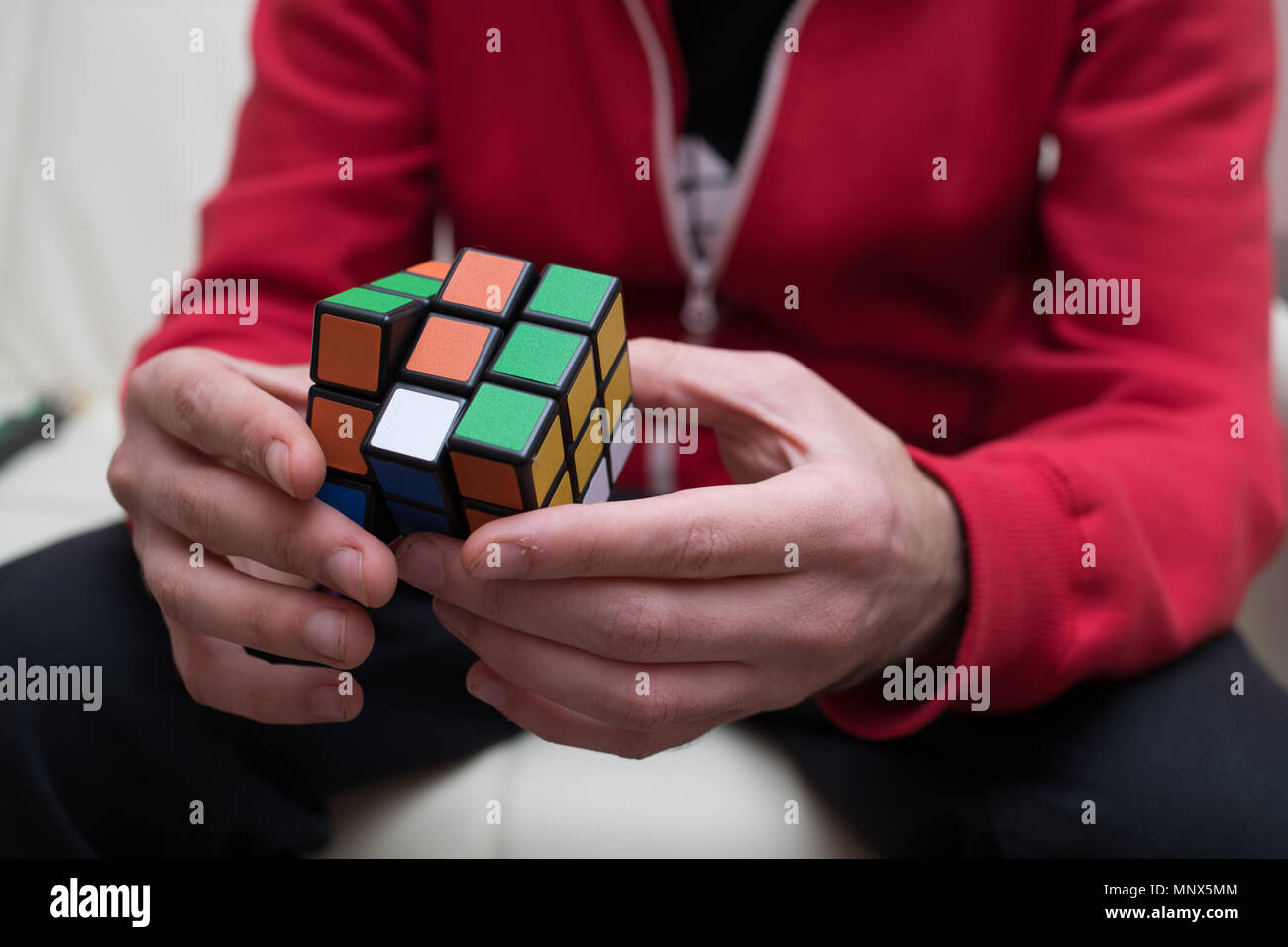 Mains d'un gars recueillir un puzzle cube coloré Banque D'Images