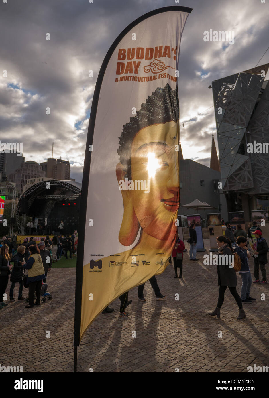 La fin de l'après-midi par sun streaming Festival Bouddha rétroéclairage bannière image de Bouddha avec de longues ombres de personnes à pied en arrière-plan. Banque D'Images