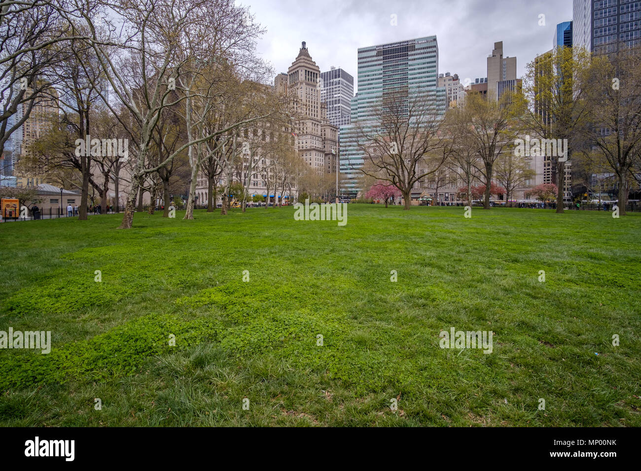 L'herbe verte et des arbres dans le parc de la batterie contre les toits de Manhattan à New York, USA. Le 30 avril 2018. Banque D'Images