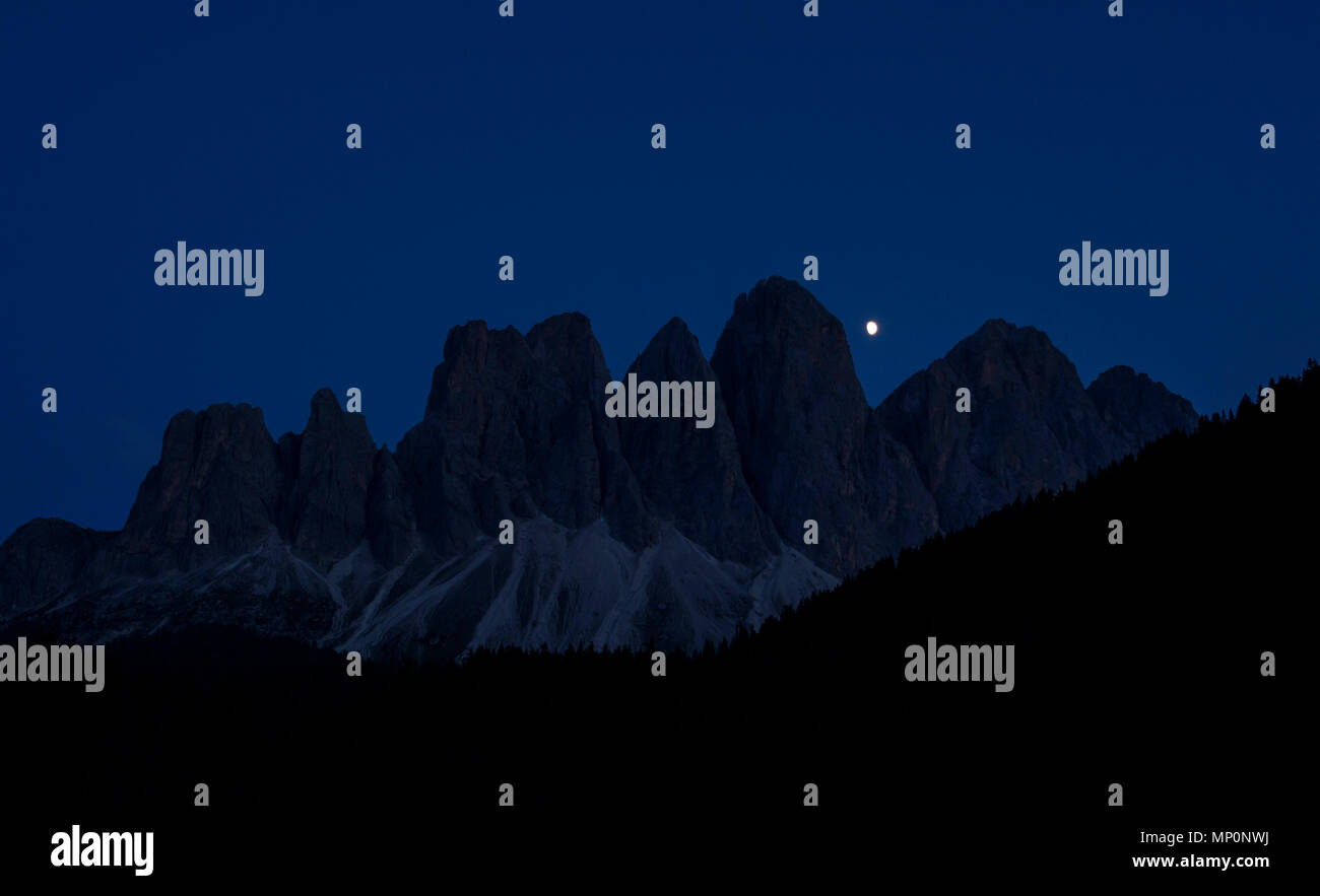 La lune et les Odle groupe de montagnes, une partie du parc naturel Puez-Odle Dolomites à Funes, province de Bolzano - Tyrol du Sud, Italie. Banque D'Images