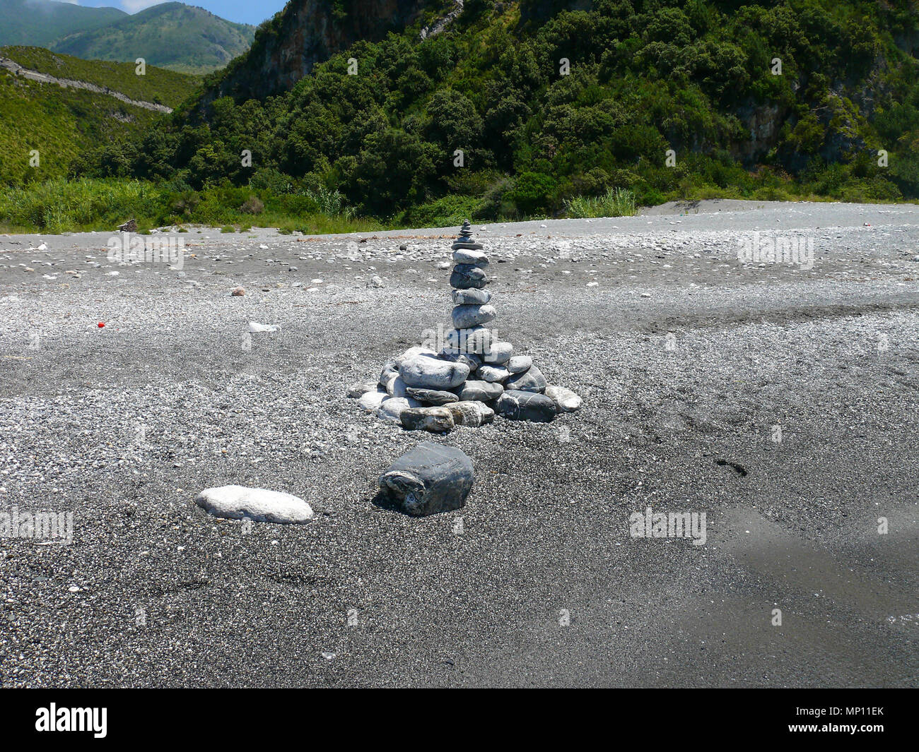 Belle stony land art sur la plage de galets noirs de Calabre près de Dino island Banque D'Images
