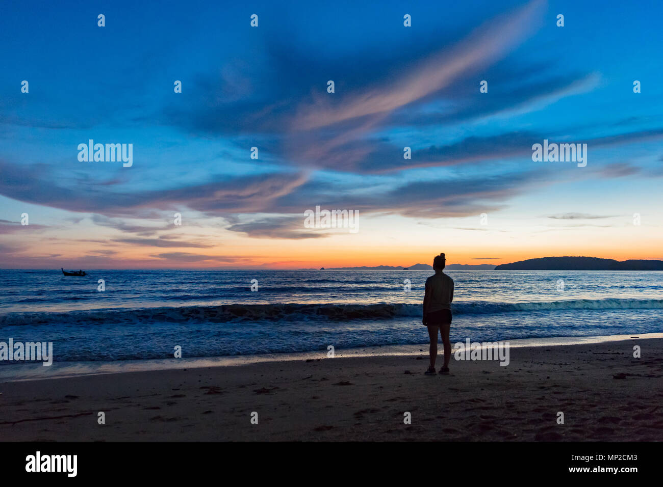 Silhouette femme debout à la plage pendant le coucher du soleil Banque D'Images