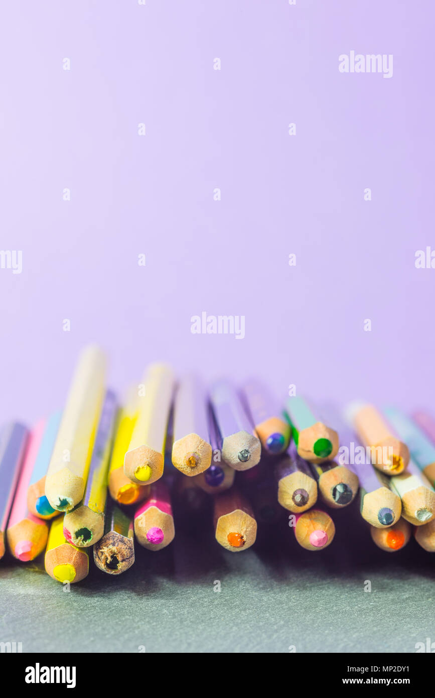 Très utilisé des crayons de couleurs différentes isolé sur un fond lilas. Concept de pièces pour acheter de nouveaux Banque D'Images