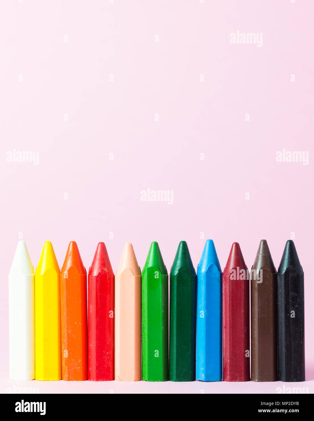 De nouveaux crayons de cire de différentes couleurs isolé sur un fond rose Banque D'Images