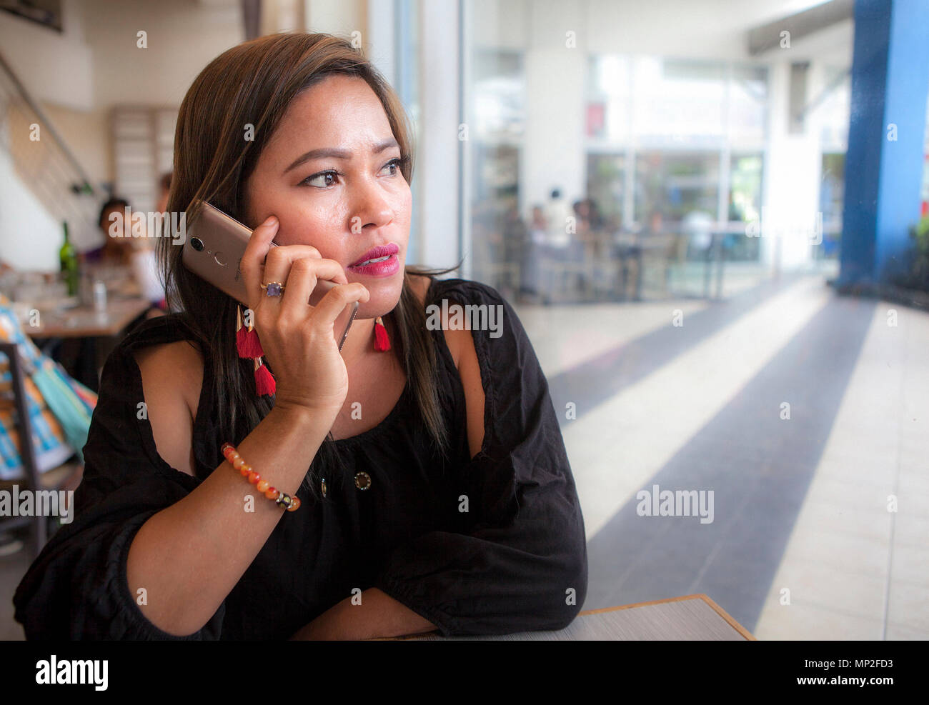 Philippine attractive businesswoman talking on her smartphone à la recherche d'un côté. Aux Philippines. Banque D'Images