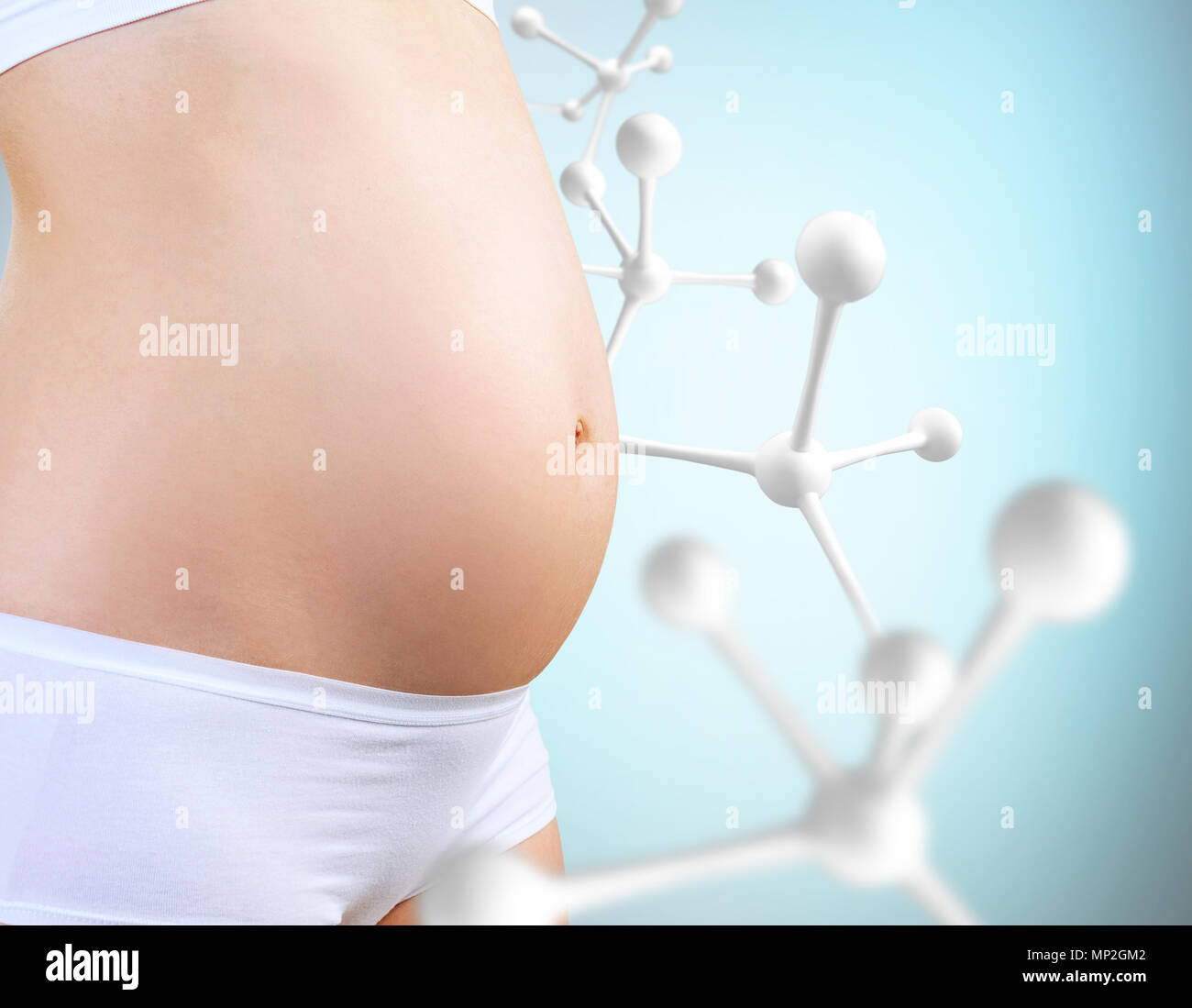 Jeune femme enceinte se caresser le ventre près de Big White molécule. Banque D'Images