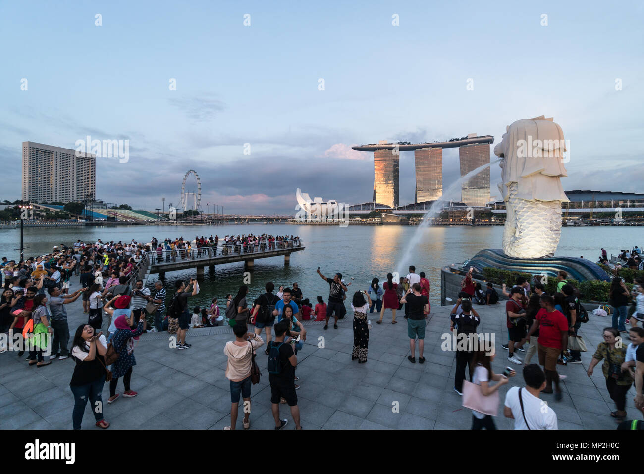 Singapour - 13 mai 2018 : Une grande foule de touristes de prendre des photos et en selfies avant de la fontaine par Merlion le Marina Bay au coucher du soleil à Singapour Banque D'Images