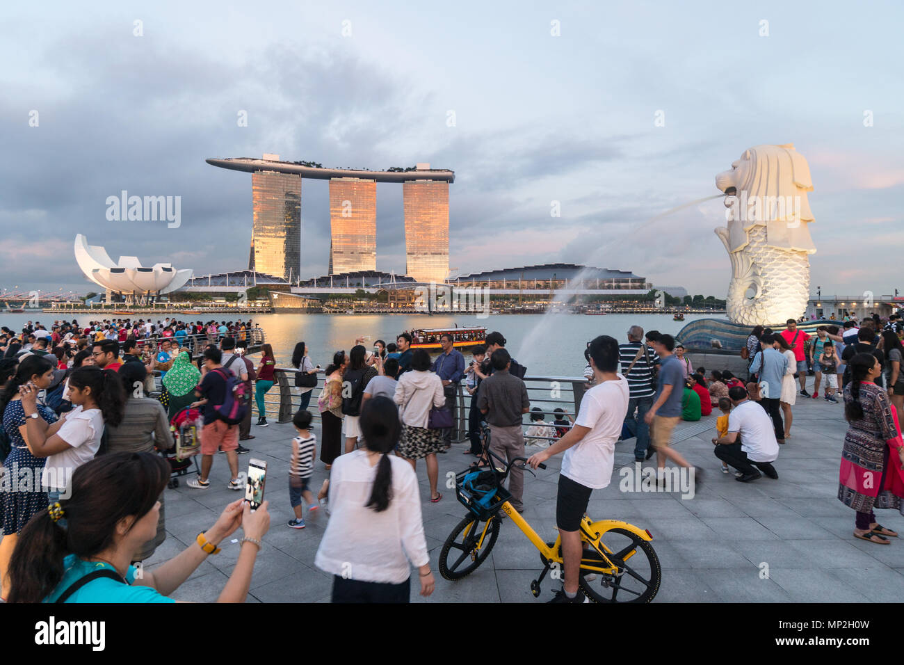 Singapour - 13 mai 2018 : Une grande foule de touristes de prendre des photos et en selfies avant de la fontaine par Merlion le Marina Bay au coucher du soleil à Singapour Banque D'Images