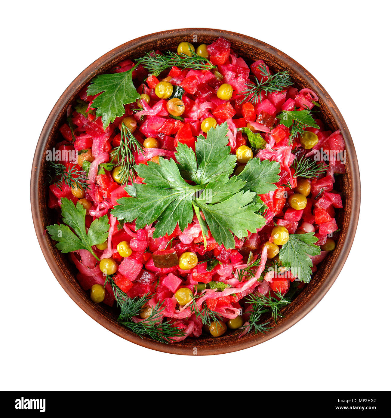 Vinaigrette salade avec des légumes bouillis, concombres, choucroute et pois verts en conserve dans une cuvette d'argile isolé sur blanc. Sn traditionnel russe Banque D'Images