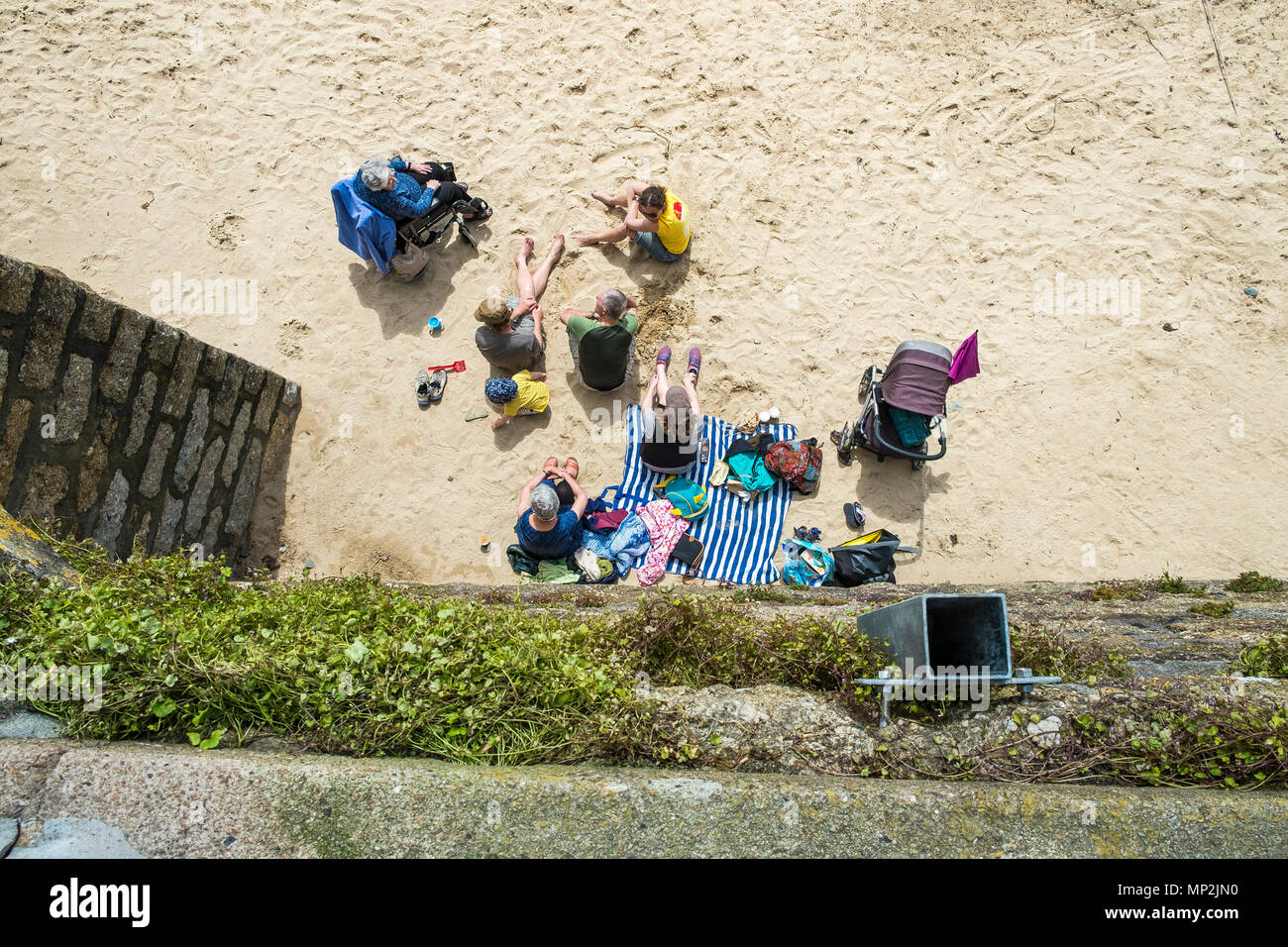 Une vue de dessus d'un des vacanciers assis sur la plage à Port Mousehole à Cornwall. Banque D'Images