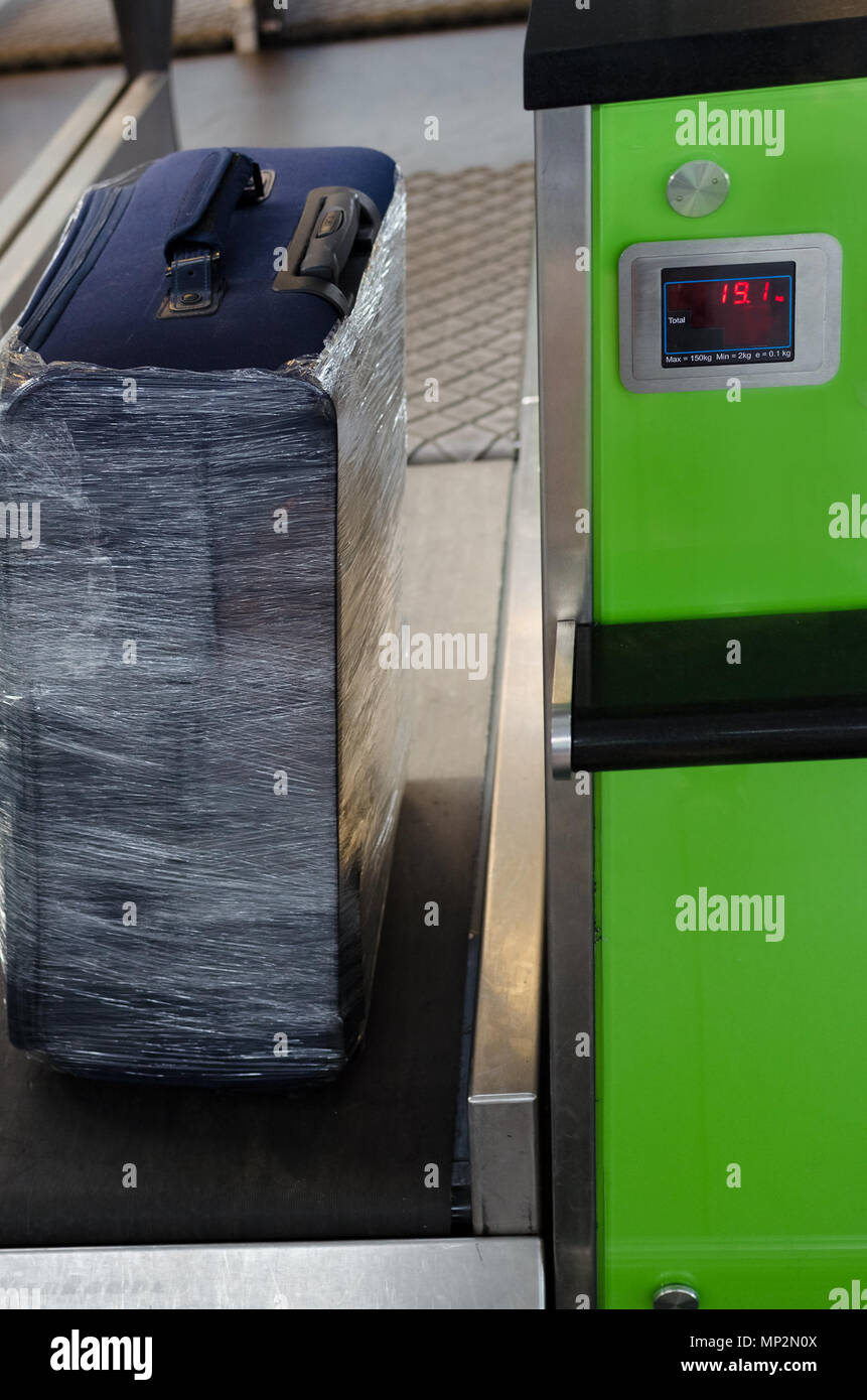 Contrôle du poids des bagages dans l'aéroport au moment de l'enregistrement par les compagnies aériennes à bas prix de restrictions. Rétractable bagages avant de voyager par avion. Suitc Banque D'Images