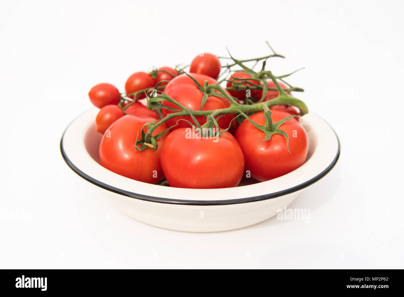 Les tomates de vigne rouge dans un bol blanc Banque D'Images