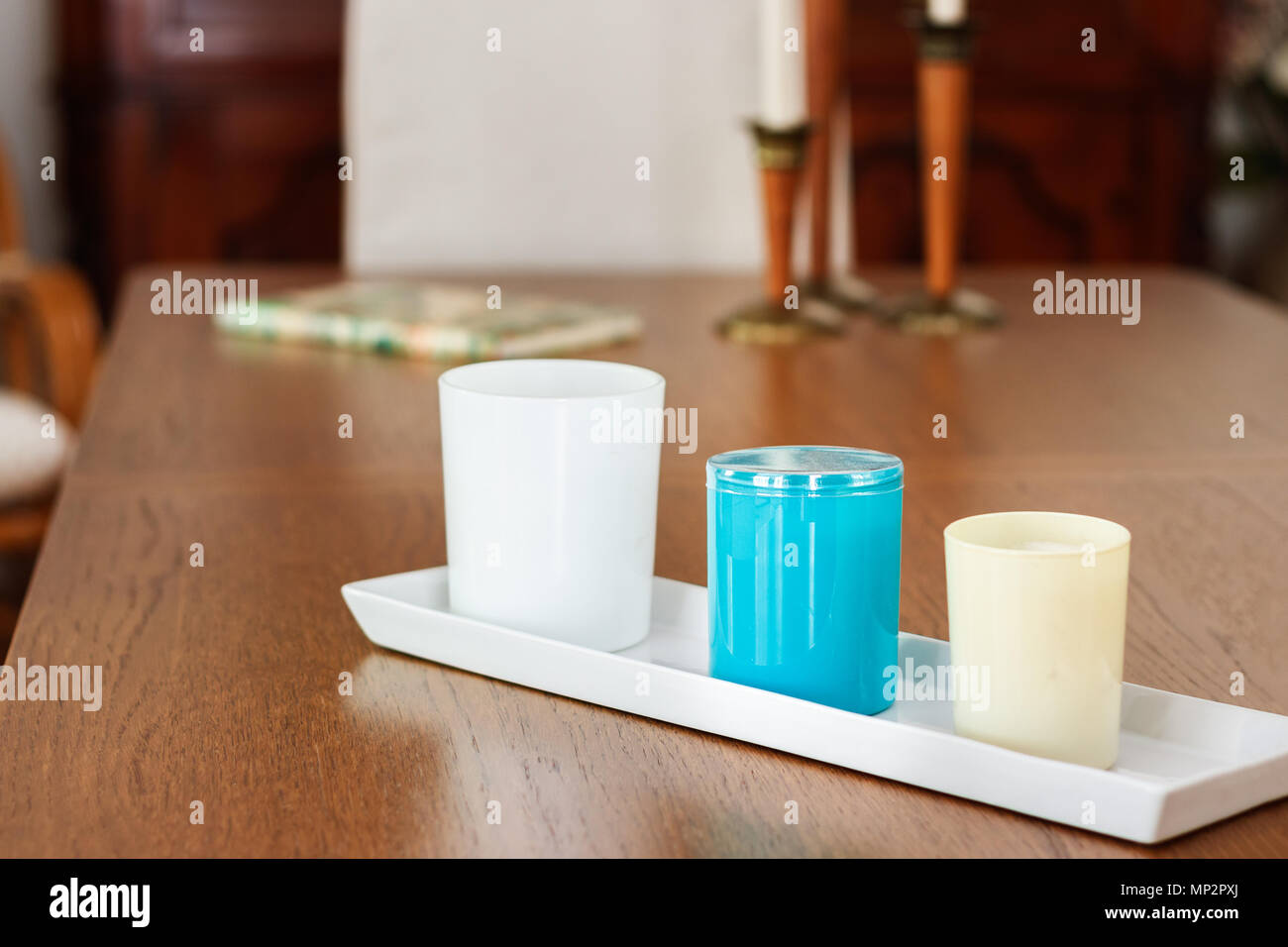 Trois chandelles avec parfums de tailles différentes placés sur une table en bois Salle à manger, de l'intérieur, lumière naturelle. Banque D'Images