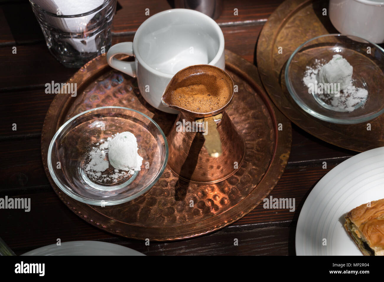 Une marmite en cuivre avec du café traditionnel grec sur un plateau avec  une tasse blanche et un joli loukumi Photo Stock - Alamy