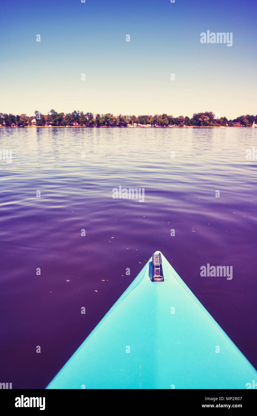 Proue d'un kayak sur un lac au coucher du soleil, toujours dans des tons de couleur photo, selective focus. Banque D'Images Proue d'un kayak sur un lac au coucher du soleil, toujours dans des tons de couleur photo, selective focus. Banque D'Images