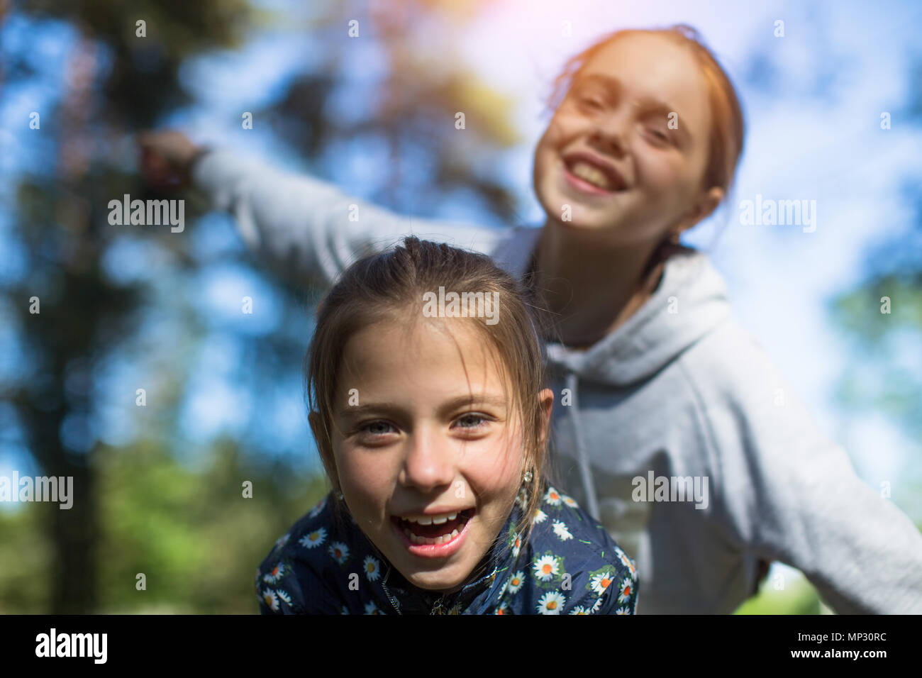 Deux soeurs filles adolescents jouer s'amuser à la recherche de l'appareil photo. Banque D'Images