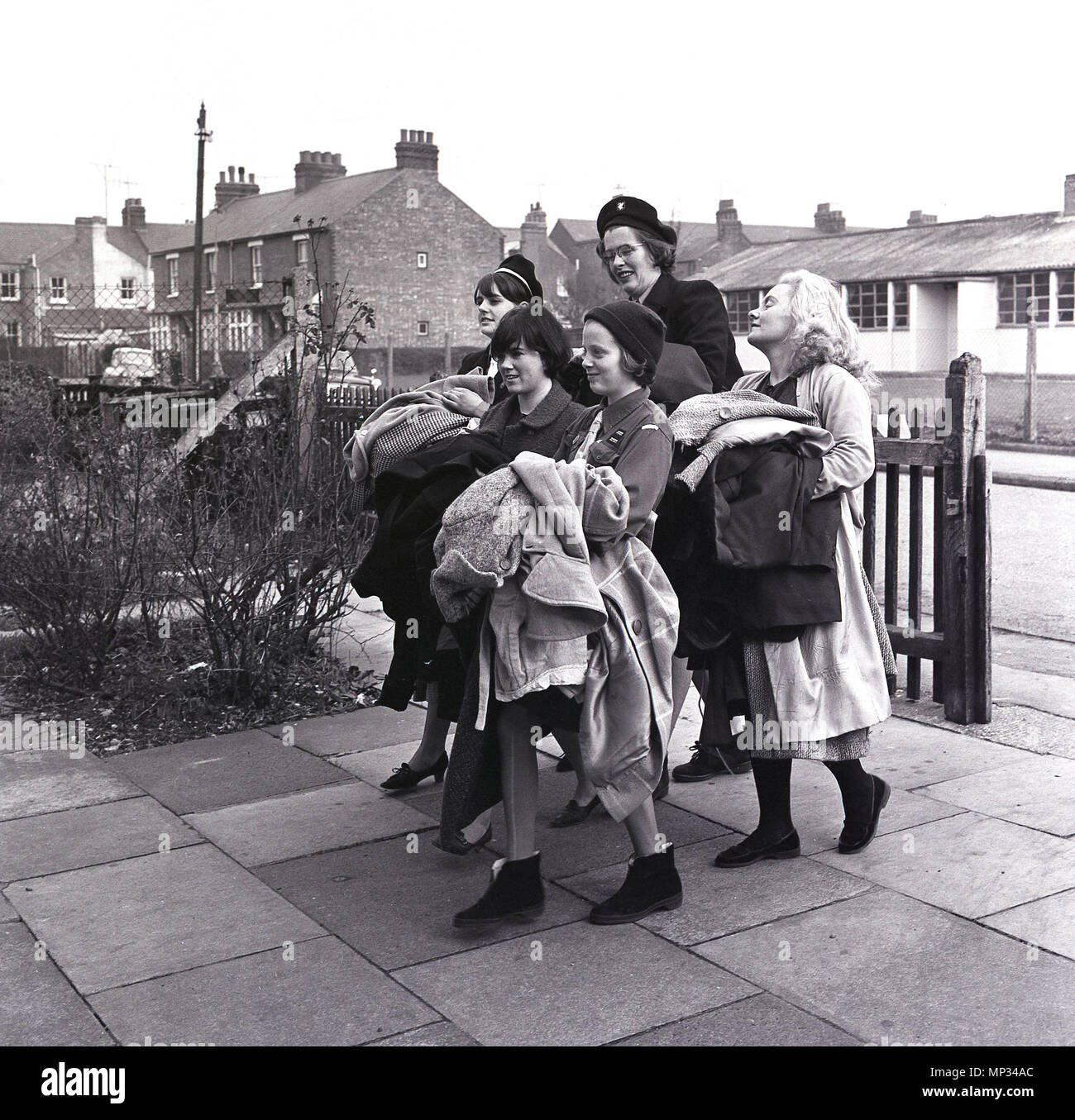 1960, l'Angleterre, l'image montre un groupe de guides réunissant les articles de vêtements de seconde main pour être vendu à une salle communautaire locale. Avant que les boutiques de bienfaisance, l'église locale et des salles communautaires lieu de vente fait don de vêtements et de ménage bric-à-brac. Banque D'Images