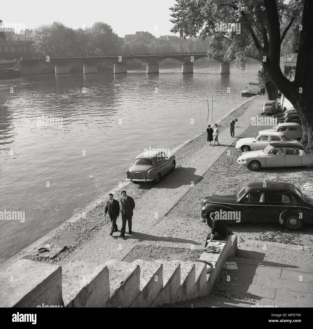 Années 1950, historique de la Seine à Paris, France avec l'ère de l'automobile française stationnée le long de la berge. Banque D'Images