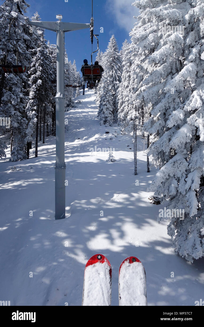 Un couple ride le télésiège à travers un paysage de neige fraîchement. Golte ski resort, la Slovénie. Banque D'Images