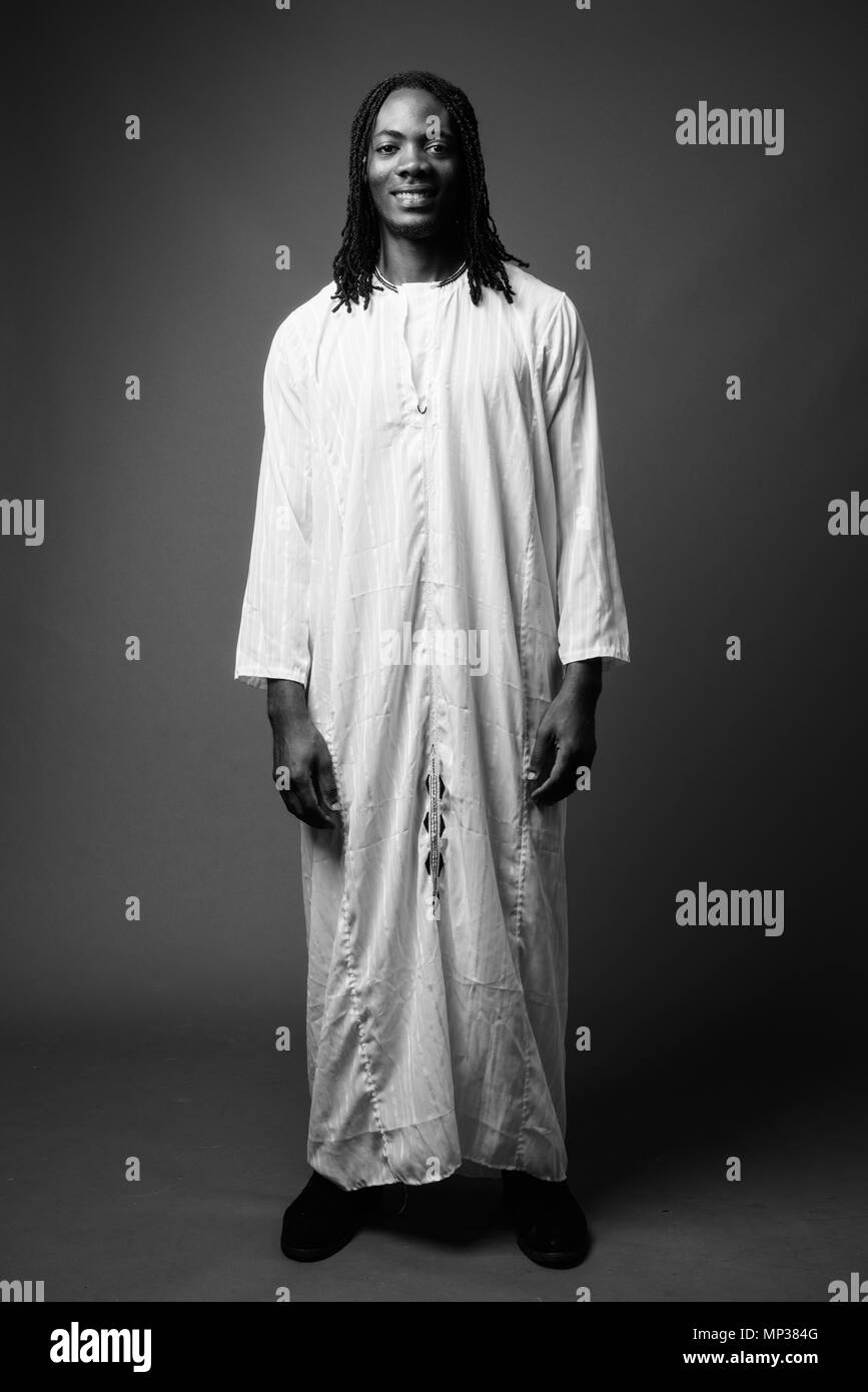 Beau jeune homme africain portant des vêtements traditionnels en noir Banque D'Images