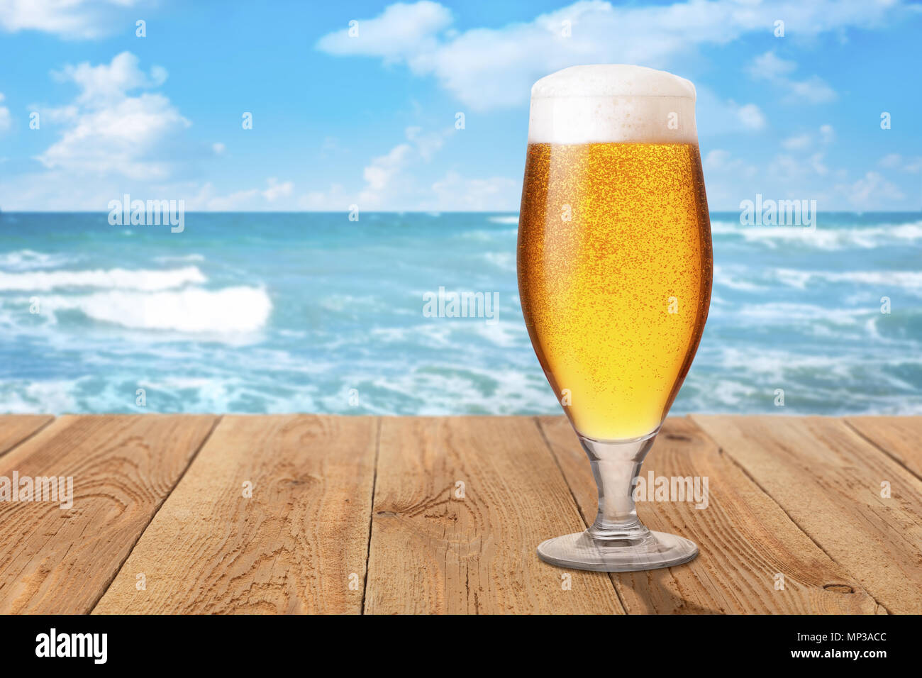 Verre de bière légère de mousse et de bulles sur table en bois contre la mer. Concept de repos et les vacances d'été Banque D'Images