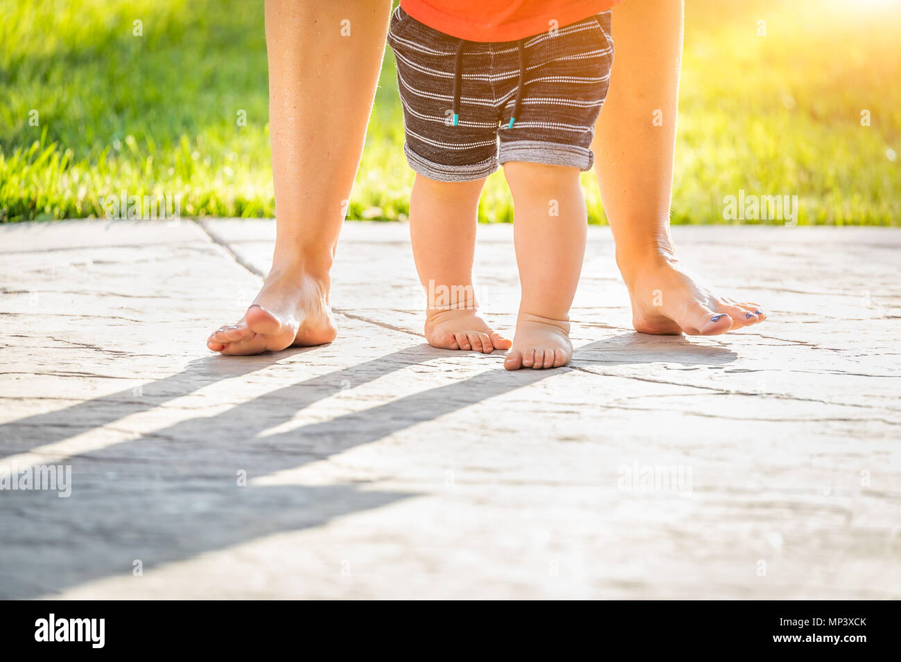 Mère et Bébé pieds prend des mesures à l'extérieur. Banque D'Images