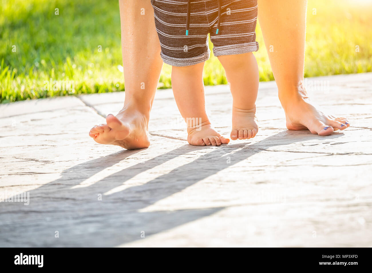 Mère et Bébé pieds prend des mesures à l'extérieur. Banque D'Images