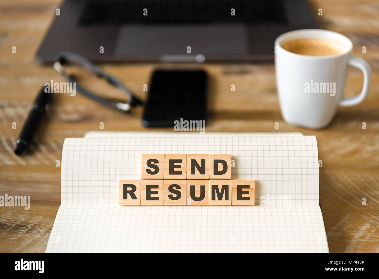 Gros plan sur ordinateur portable sur la table de bois, l'arrière-plan l'accent sur des pièces en bois avec des lettres faisant Envoyer texte du CV. Concept d'image. Banque D'Images