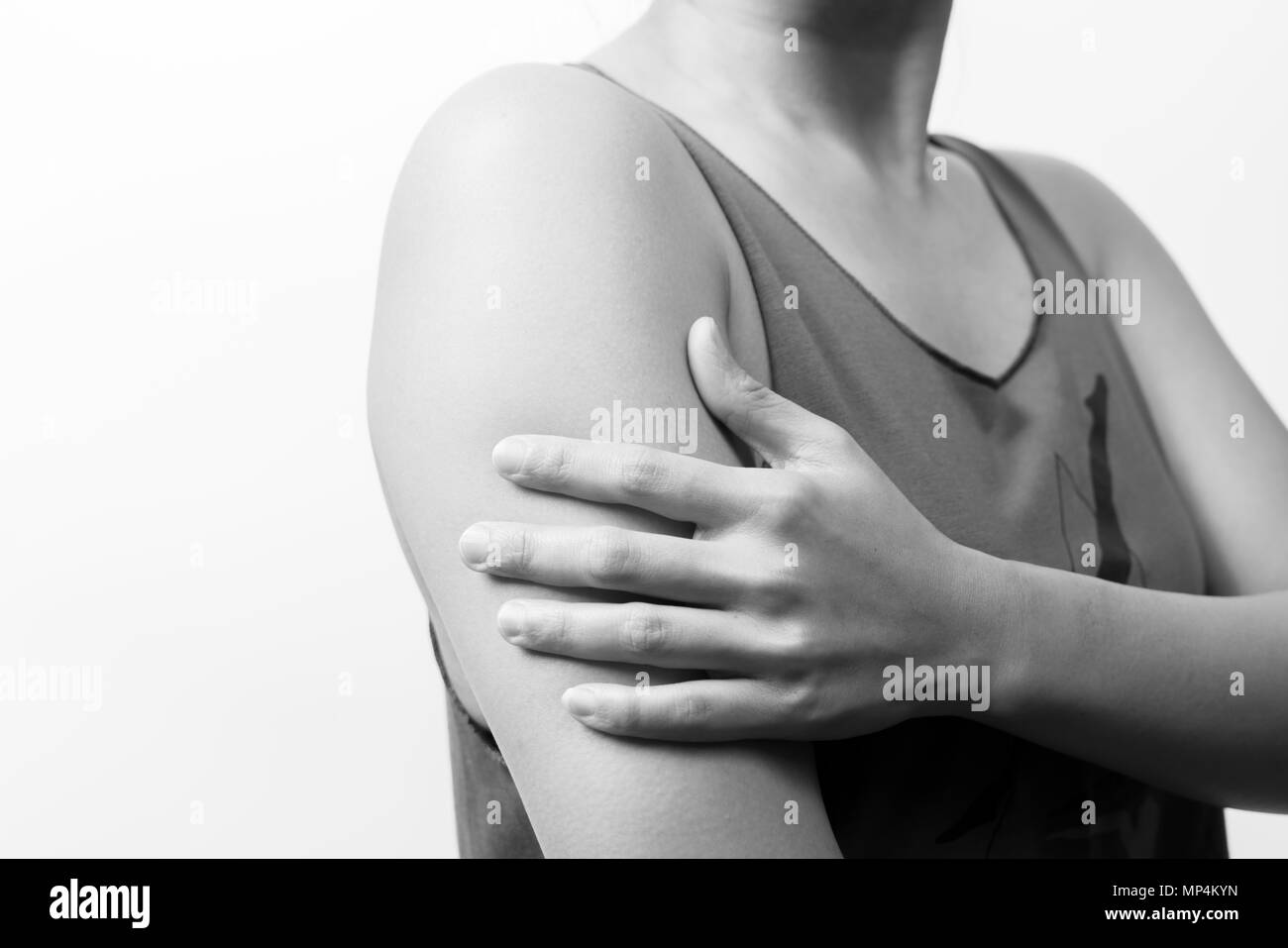 Les femmes et le bras libre de la douleur de l'épaule et de blessures avec fonds blancs, de la santé et médical concept - B&W filter Banque D'Images