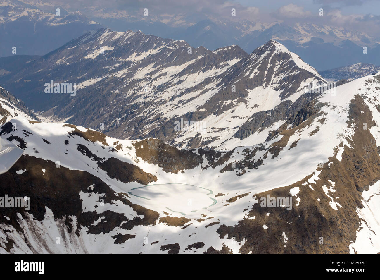 Vue aérienne, à partir d'un petit avion, de la fonte des glaces et la fin du printemps la neige sur le lac Moro, tourné par un beau jour de printemps dans les montagnes, Bergame Orobie , Itali Banque D'Images