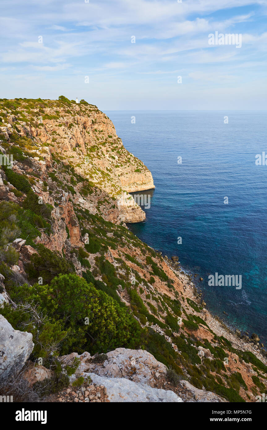 Vue panoramique de Punta de Sa Ruda mer et falaises environnantes avec phare de La Mola, près d'El Pilar de la Mola (Formentera, Iles Baléares, Espagne) Banque D'Images