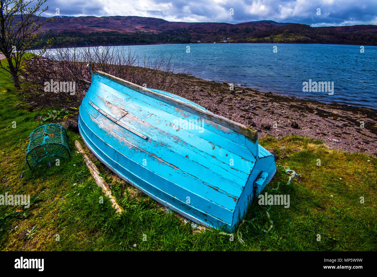 Barque bleue sur le rivage à Shieldaig dans les Highlands d'Ecosse Banque D'Images