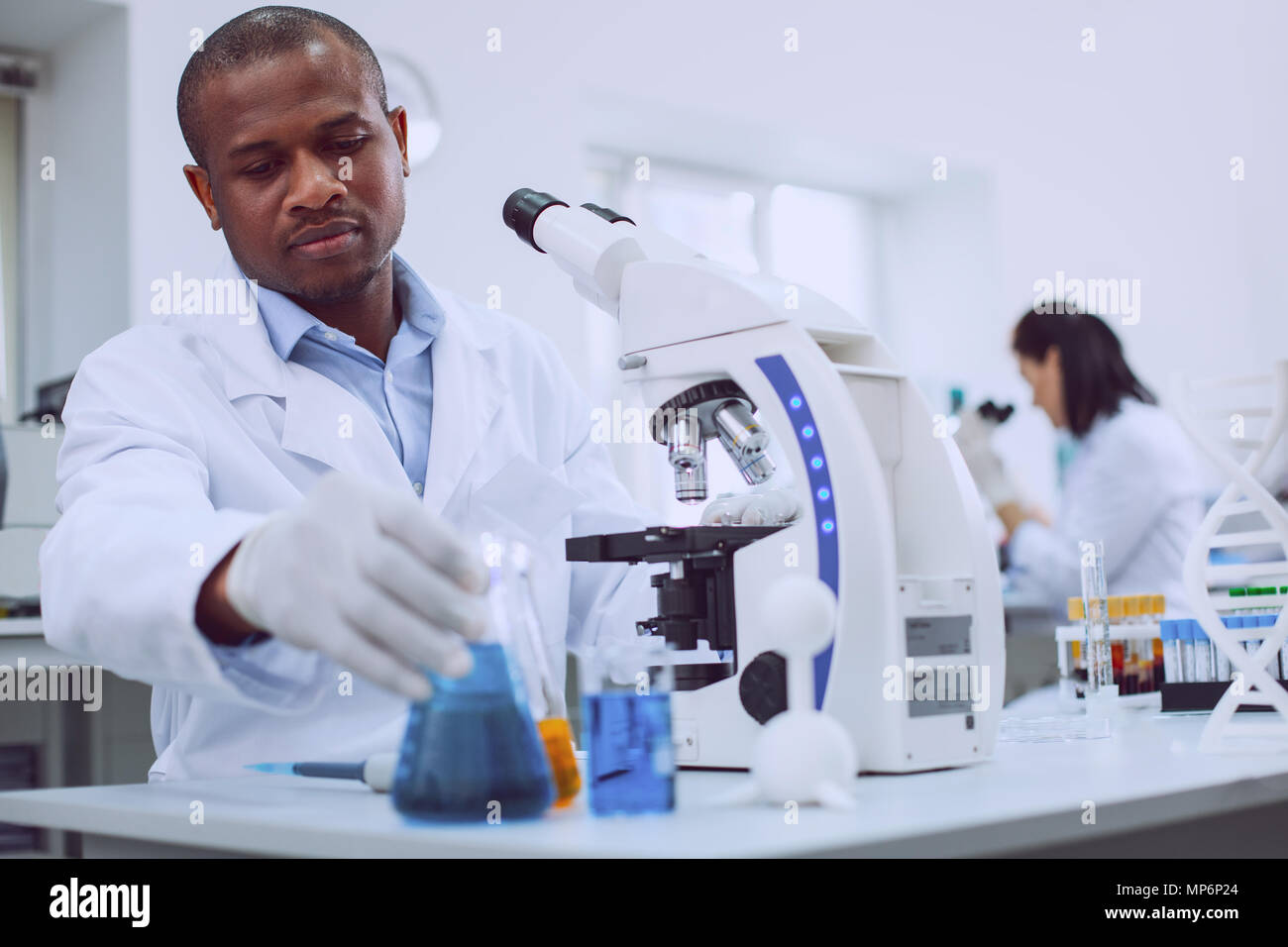 Homme déterminé chercheur travaillant avec son microscope Banque D'Images