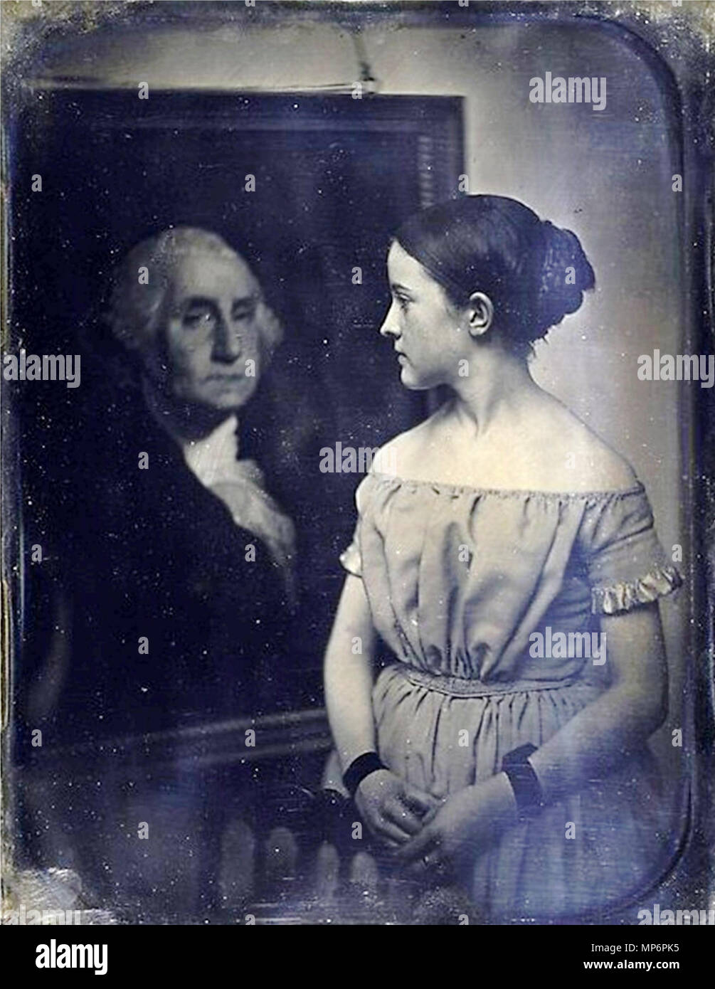 Anglais : Photographie d'une jeune fille avec portrait de George Washington. English : Photographie d'une jeune fille avec le portrait de George Washington. Anglais : Ce portrait fascinant semble aussi être une allégorie de l'allégeance, dans lequel la jeune fille dirige l'attention du spectateur retour à la célèbre peinture de George Washington. Des études récentes suggèrent que ce daguerréotype est en fait une copie d'un autre daguerréotype, ajoutant encore à la complexité des Jeux de regards, mais encore comme l'objet et la signification exacte de cette image énigmatique ne sont pas connus. Français : Ce portrait envoûtant se Banque D'Images