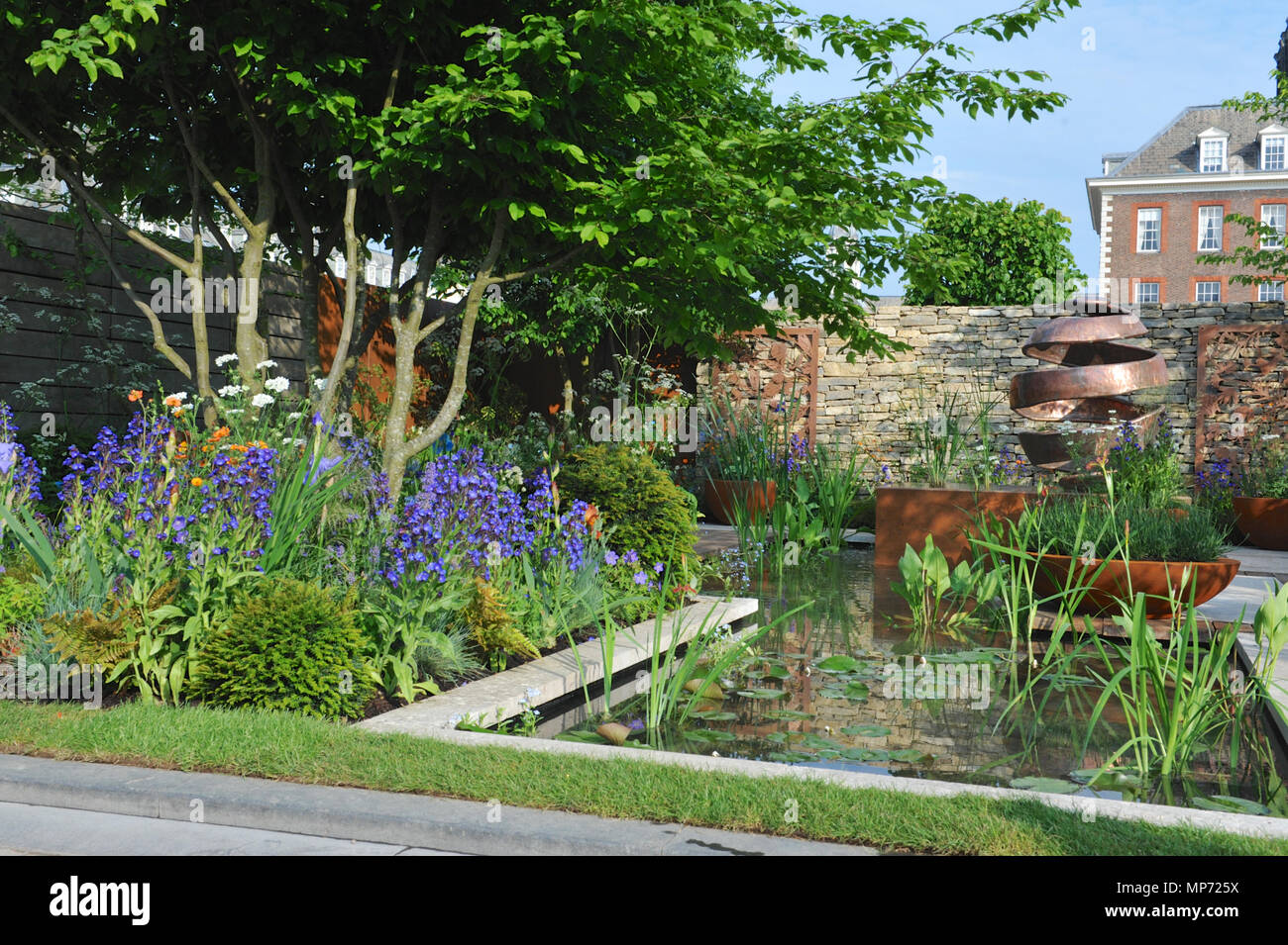 Londres, Royaume-Uni. 21 mai 2018. La piscine jardin silencieux Gin (conçu par David Neale), l'un des beaux et élégants jardins afficher sur l'affichage à l'2018 RHS Chelsea Flower Show qui a ouvert ses portes aujourd'hui dans les 11 acres de terrain de l'Hôpital Royal de Chelsea, Londres, Royaume-Uni. La piscine jardin silencieux Gin' est destiné à un couple de professionnels qui vivent dans la ville et un espace d'échapper à et vous détendre à partir de leurs vies occupées. Les principales caractéristiques comprennent plusieurs tiges indigènes Crataegus monogyna, un élément d'eau contemporaine avec un bord à l'infini, et une sculpture en cuivre Le cuivre, à côté des panneaux découpés au laser wh Banque D'Images