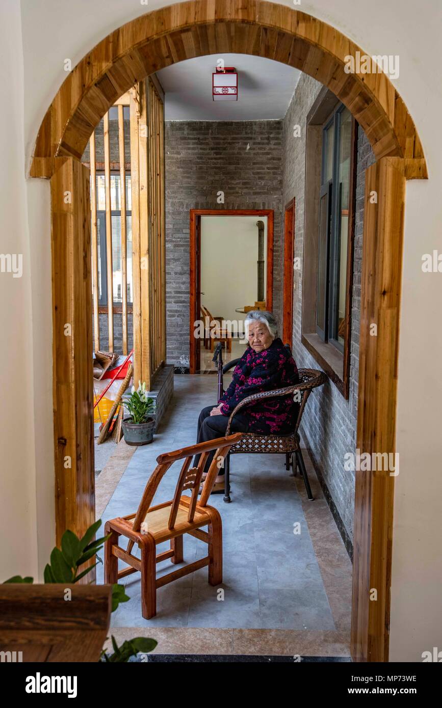 Wuhan, province du Hubei en Chine. 13 mai, 2018. Un villageois est vue à son nouveau logement en Zhongxing Building 0 Village de Gucheng, comté de la province du Hubei en Chine centrale, le 13 mai 2018. Les villageois de Zhongxing Building 0 ont planté un plateau et développé le tourisme rural depuis des années 1990. Les autorités locales ont invité des experts pour la planification des villages. Dans la classification des logements Zhongxing Building 0 Contient Adobe maison en brique, structure de bois, mur de brique, structure-structure en béton et pseudo-villa classique. Crédit : Du Huaju/Xinhua/Alamy Live News Banque D'Images