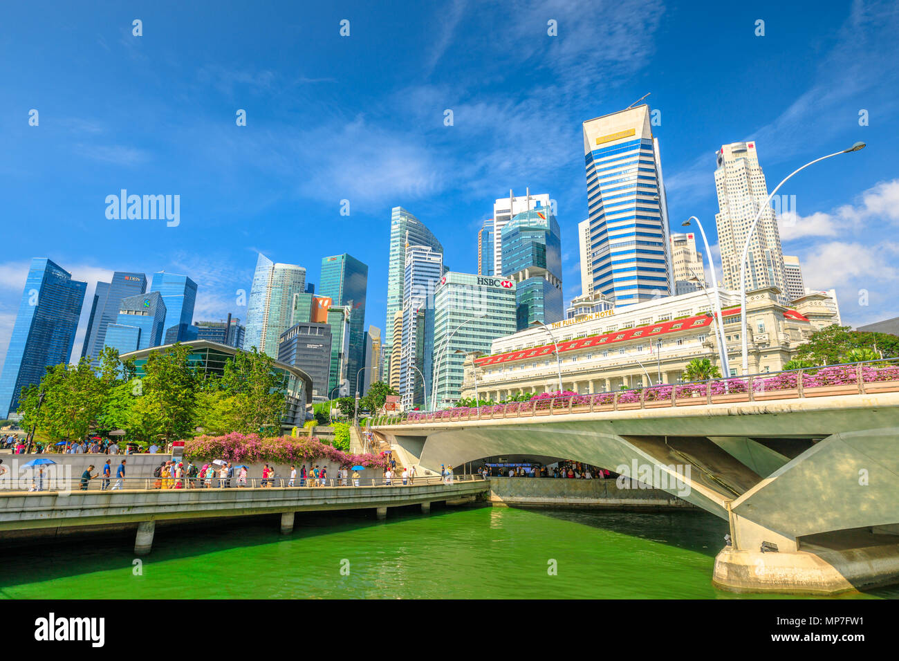 Singapour - le 28 avril 2018 : le centre-ville de Singapour avec Fullerton Hotel, des gratte-ciel du quartier des affaires, Esplanade Bridge et personnes marchant dans la Promenade de la baie de Plaisance. Journée ensoleillée avec ciel bleu. Banque D'Images