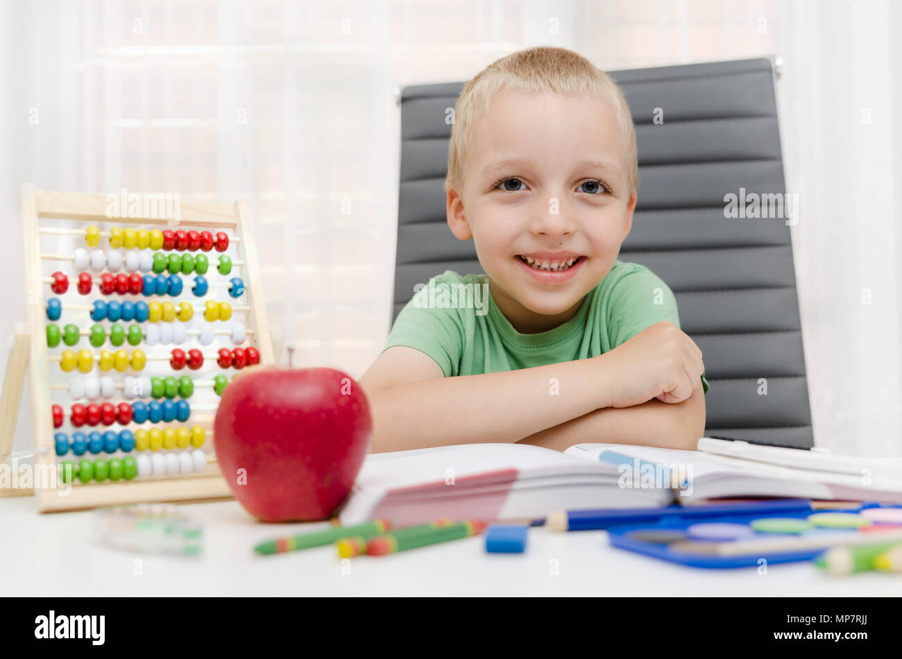 Cours préparatoire, l'étudiant fait ses devoirs sur le bureau. Enfant de l'école, petit garçon l'apprentissage à la maison. Concept de l'enseignement élémentaire Banque D'Images