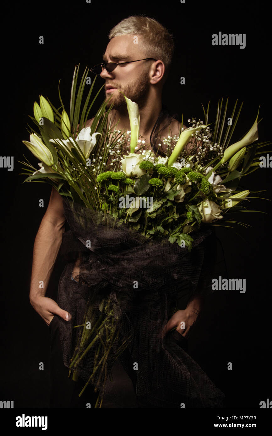 Avec l'homme élégant bouquet de fleurs blanches sur fond noir Banque D'Images